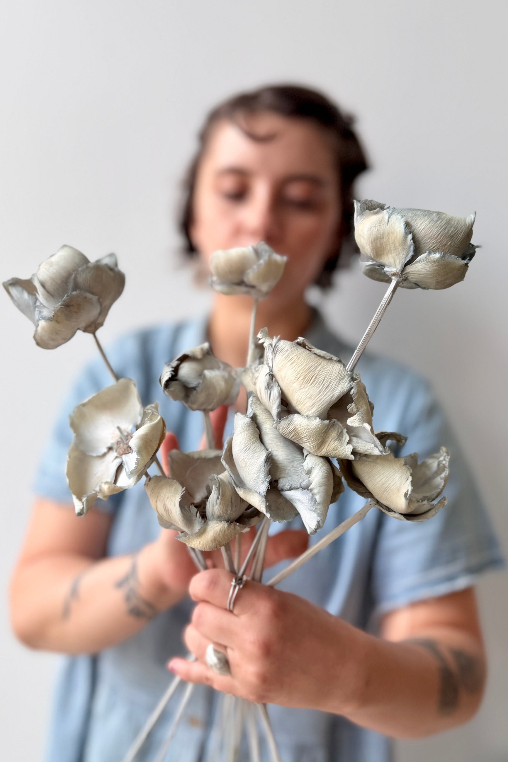 Person holding Palm Cap Gray Blue Pastel Preserved Bunch against a plain background ©Sprout Home