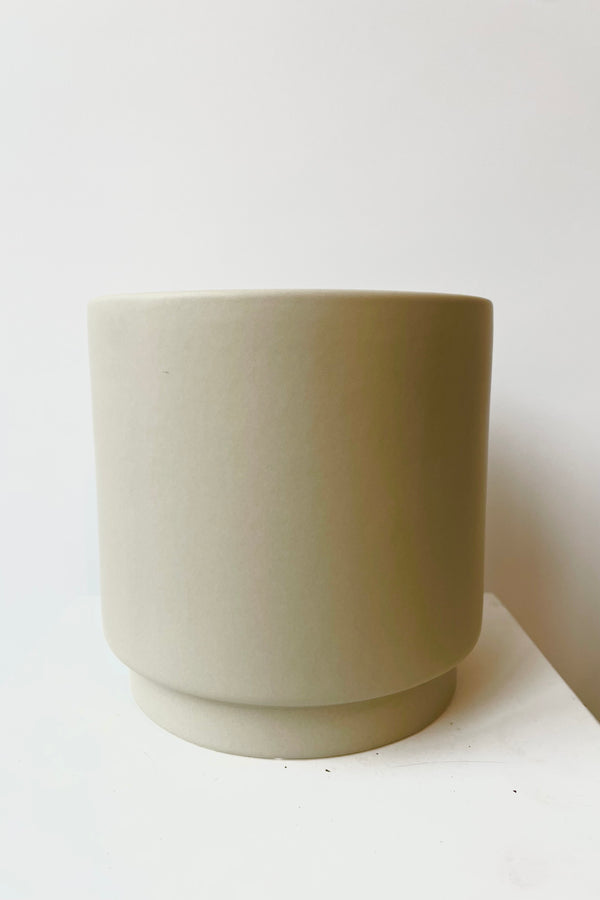 Beige ceramic urn shaped cachepot against white background