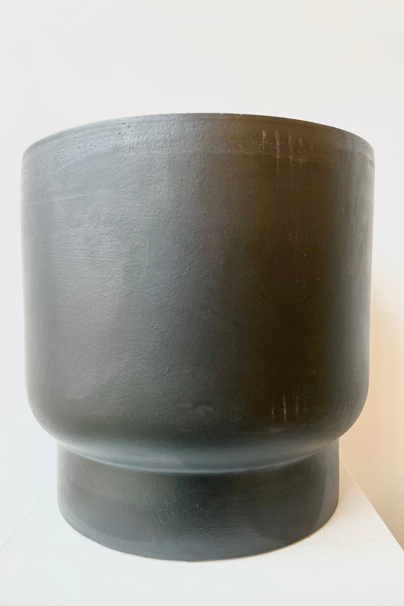 Black ceramic urn shaped cachepot against white background