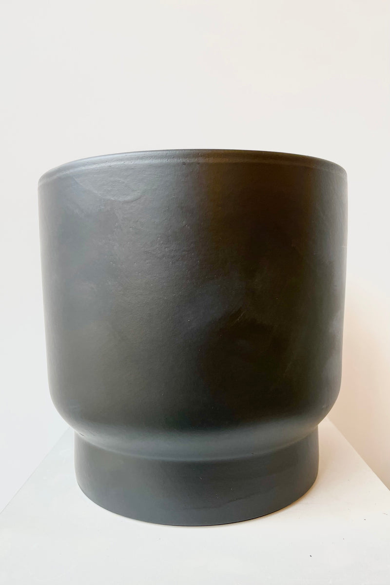 Black ceramic urn shaped cachepot medium against white background