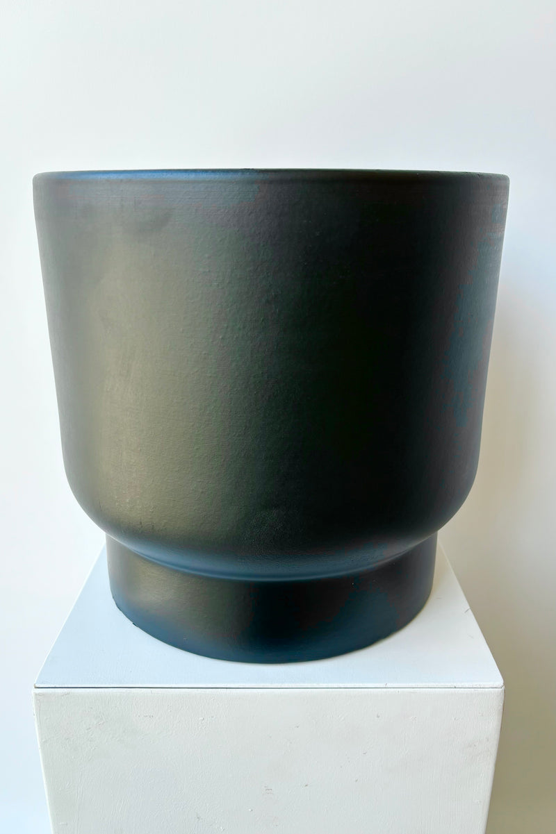 Black ceramic urn shaped cachepot against white background