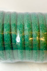 Close up of coil of green foam wrapped wire 32' length against white background