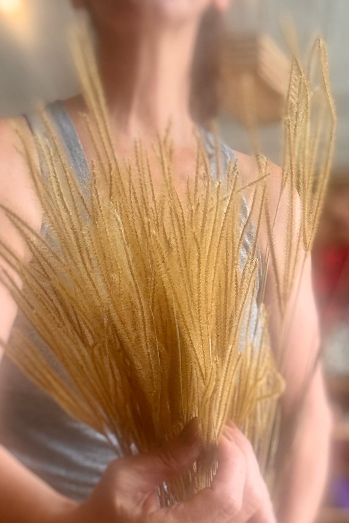 A person holding a bOuro Natural Preserved Bunch in front of their torso, with a softly blurred indoor background. ©Sprout Home