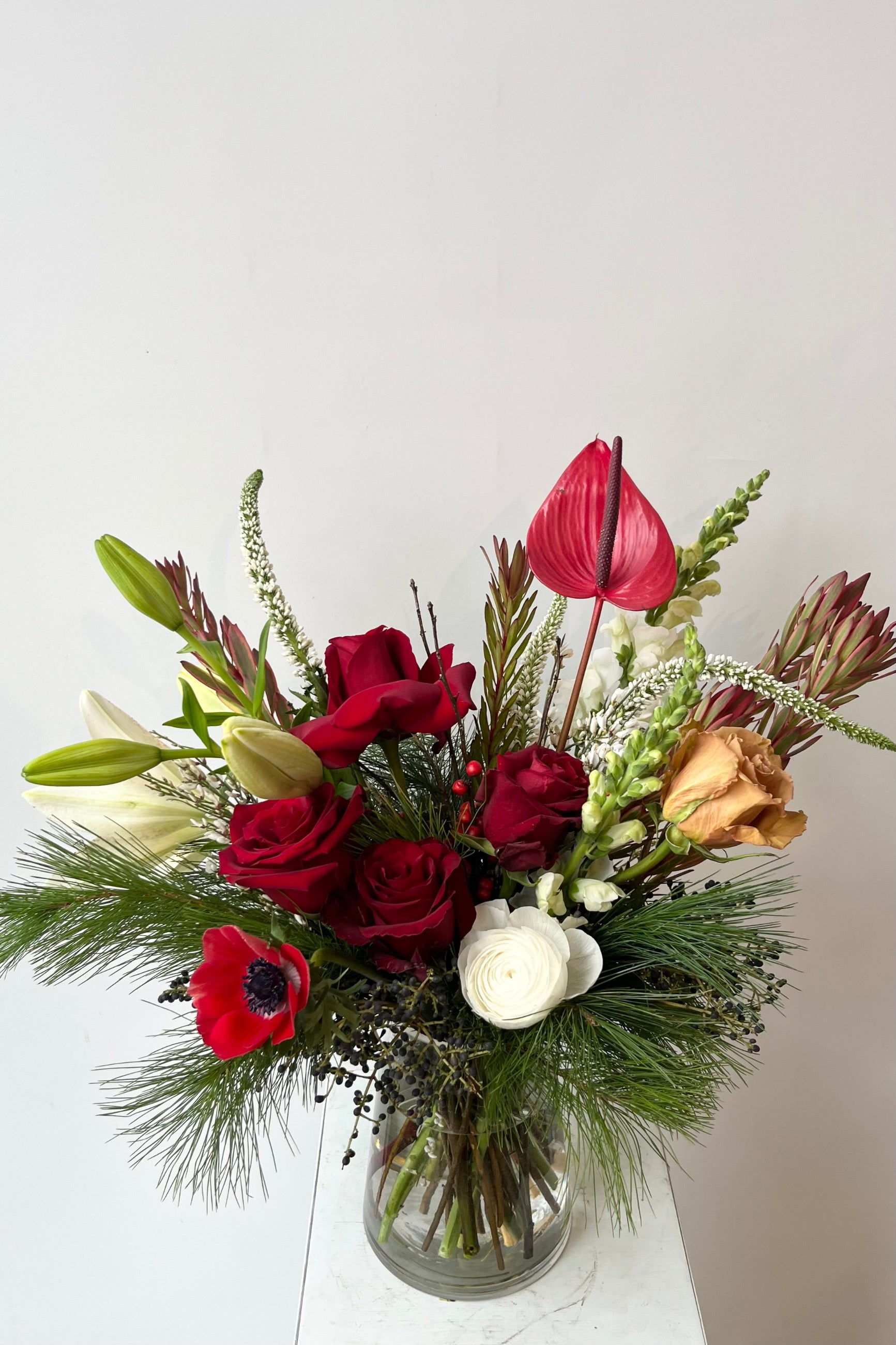 A hand holds an example of fresh Floral Arrangement Solstice with red roses and daisy from Sprout Home Floral in Chicago ©Sprout Home #size_$130