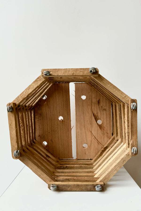 Interior of octagonal wooden slated basket against white background