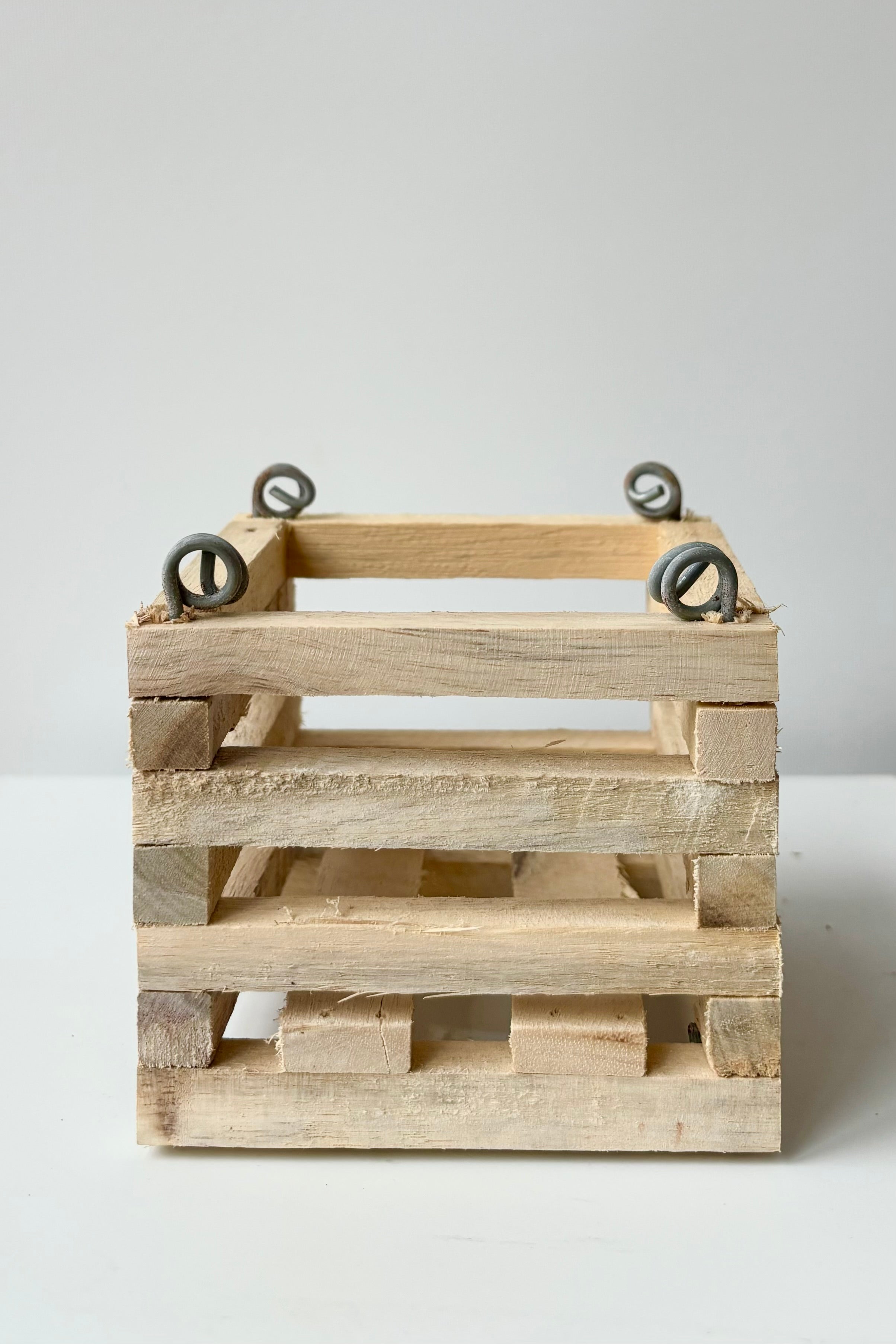 Wooden slatted vanda basket with metal rings for string attachment, not included, against white background