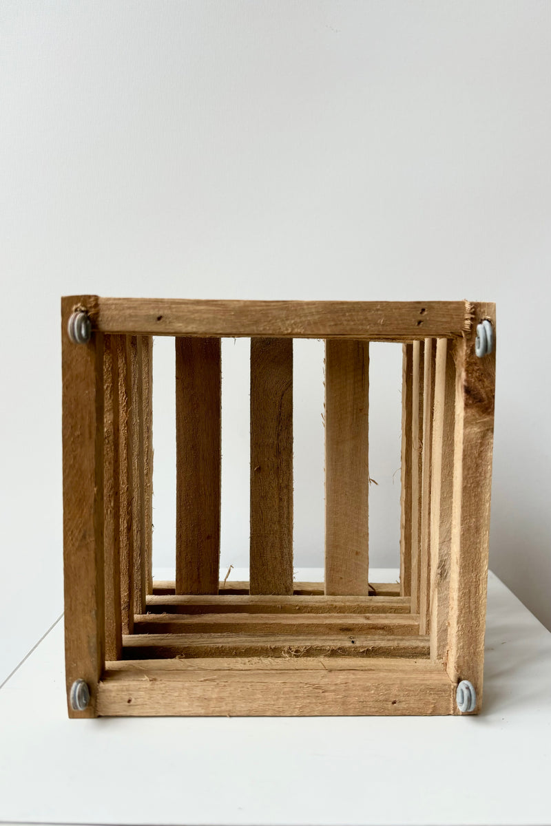 Interior of wooden slatted vanda basket with metal rings for string attachment, not included, against white background