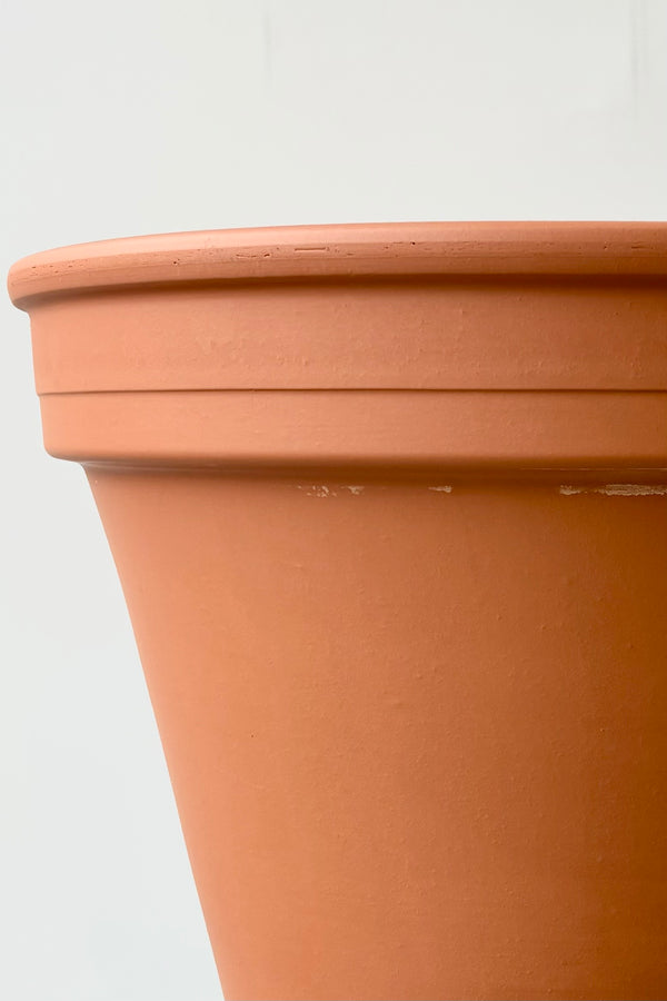 Detail of terra cotta fourteen inch clay pot against white background