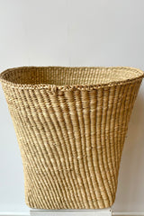 Woven grass basket, short against white background