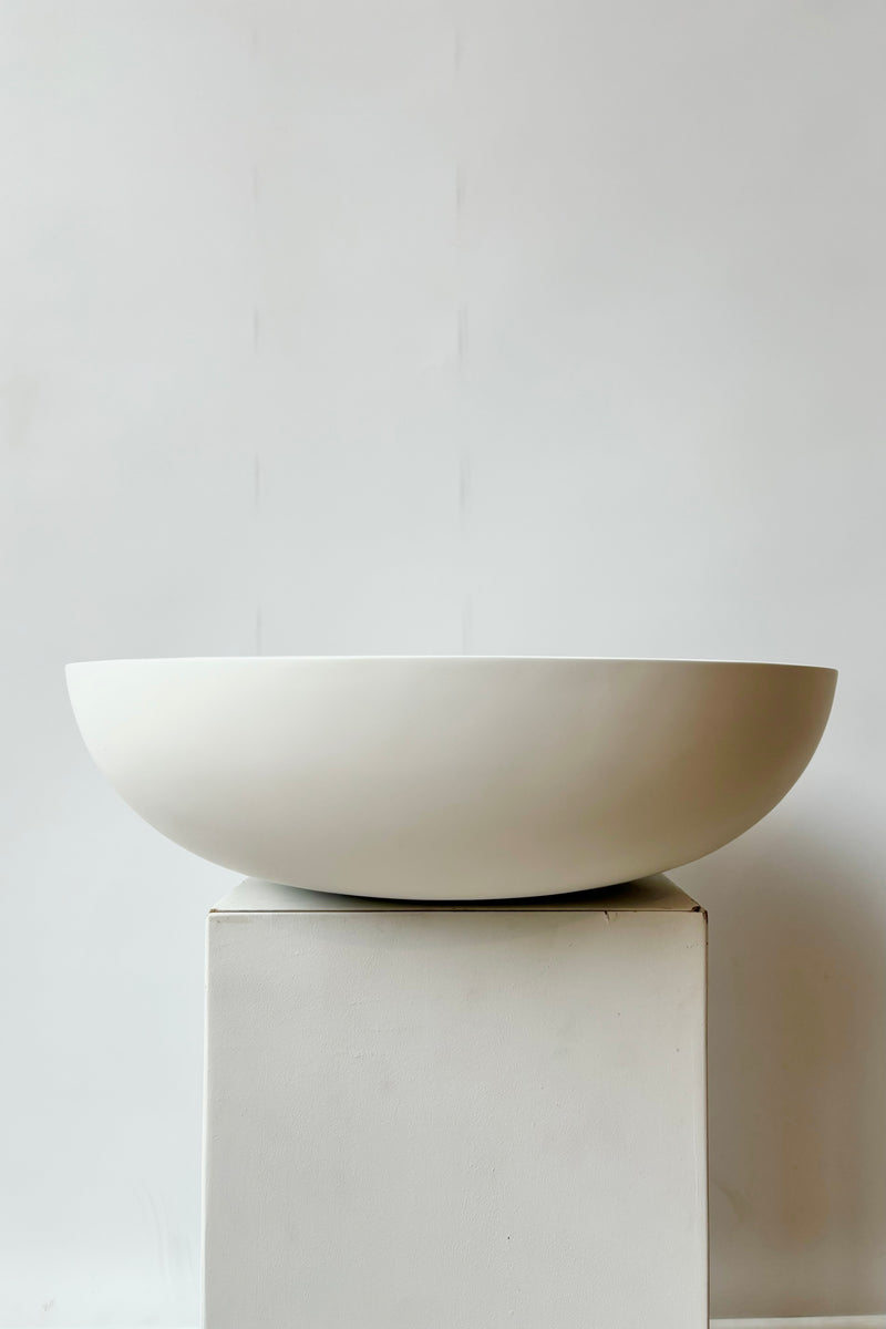 Side view of matte white, large, shallow bowl against white background