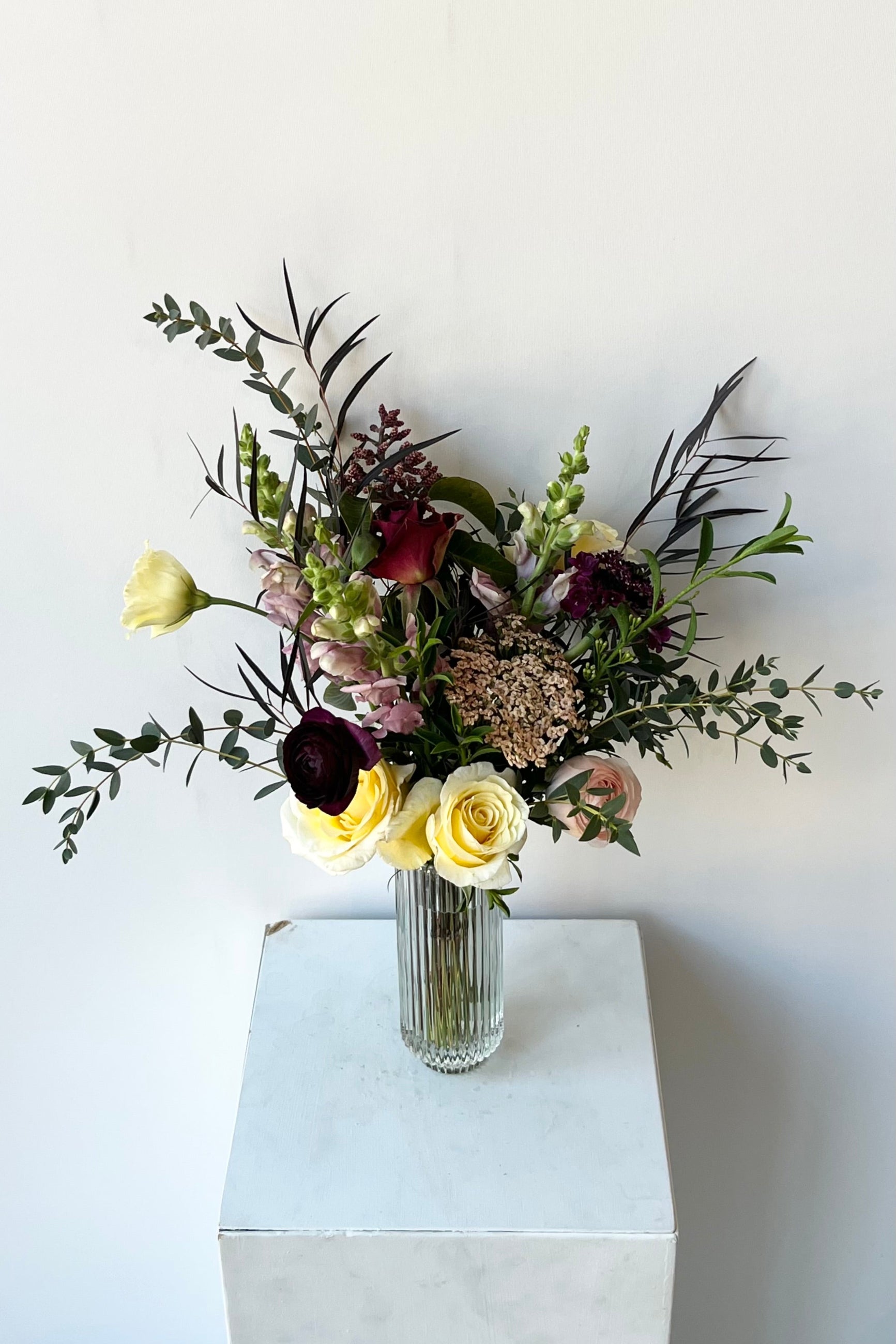 A dusk colored custom floral arrangement by Sprout Home against a white wall  ©Sprout Home #size_$75