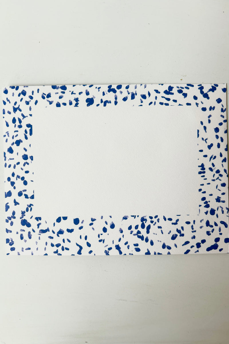 Envelope for greeting card on white paper with blue speckled border and white address box