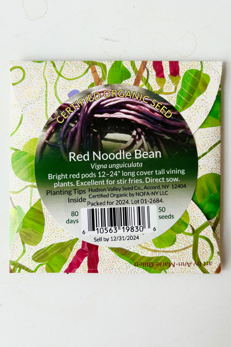 Backside of the Red Noodle Bean seed pack with a sticker that says certified organic seed and growing instructions against white background