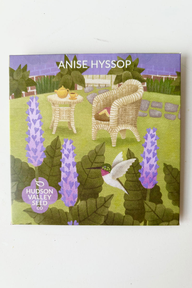 Anise Hyssop seed pack with a picture of a backyard scene with a table and chair and three purple anise flowers in front against white background