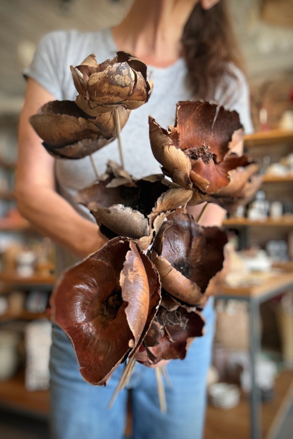 Palm Cap Natural Color Preserved Bunch being held in hand in front of a person with a gray shirt ©Sprout Home