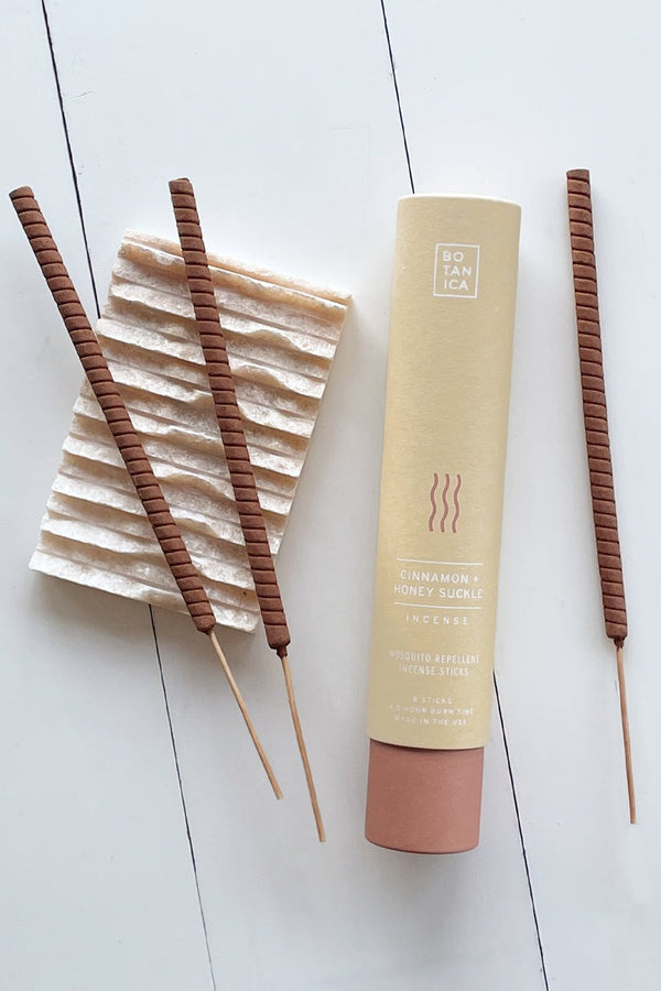 Cinnamon & Honey Suckle outdoor stick incense by Botanica. Recycled packing tube and three sticks outside the box laying flat