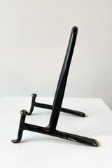 Small cast iron display stand viewed from the side. 