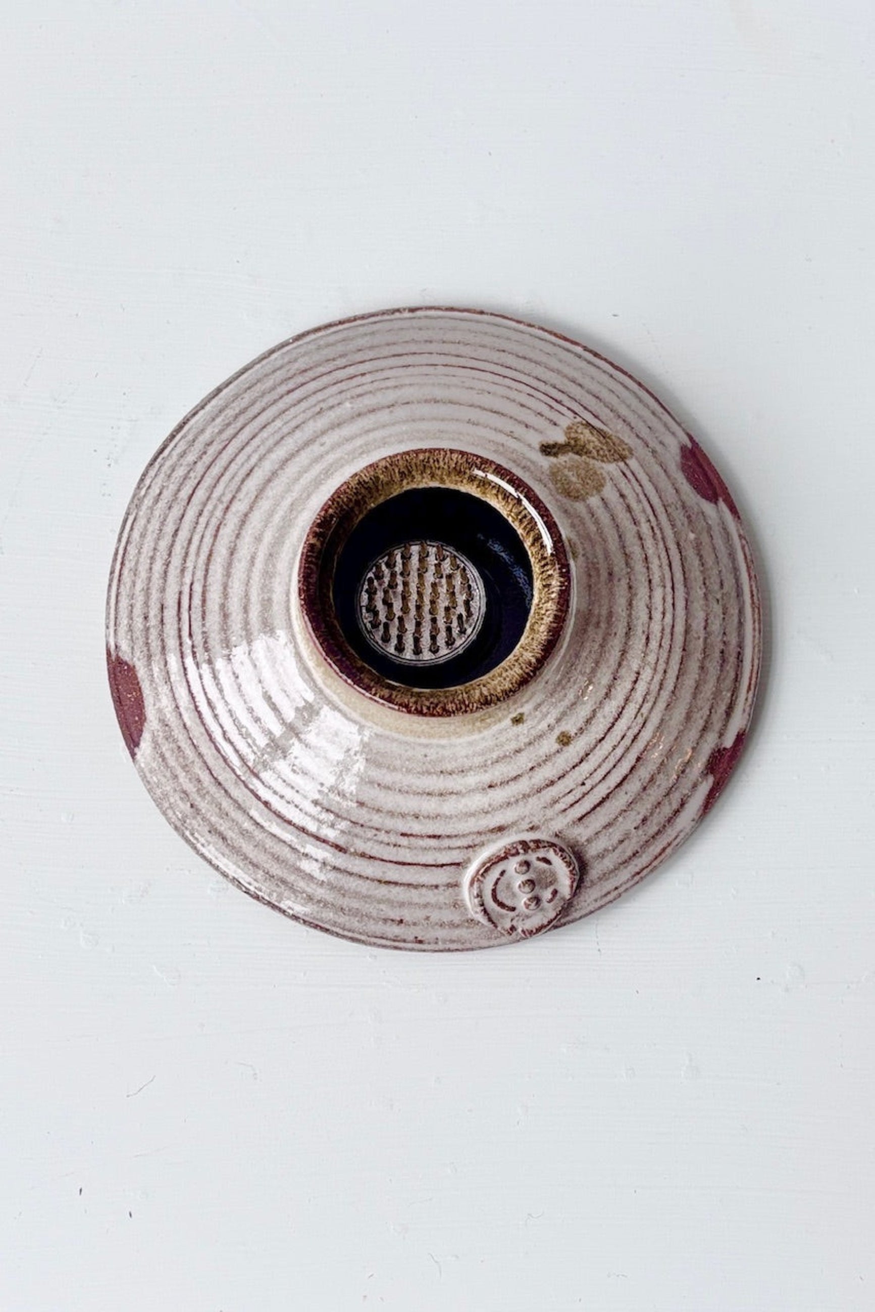 Top view of white glazed Ikebana flower vase with floral frog on a white surface ©Sprout Home