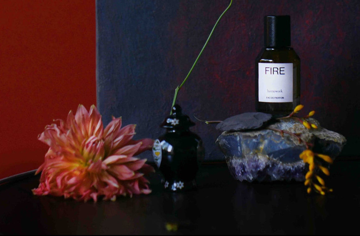 Bottle and box labeled 'FIRE' on a dark surface with a red and blue background ©Homework