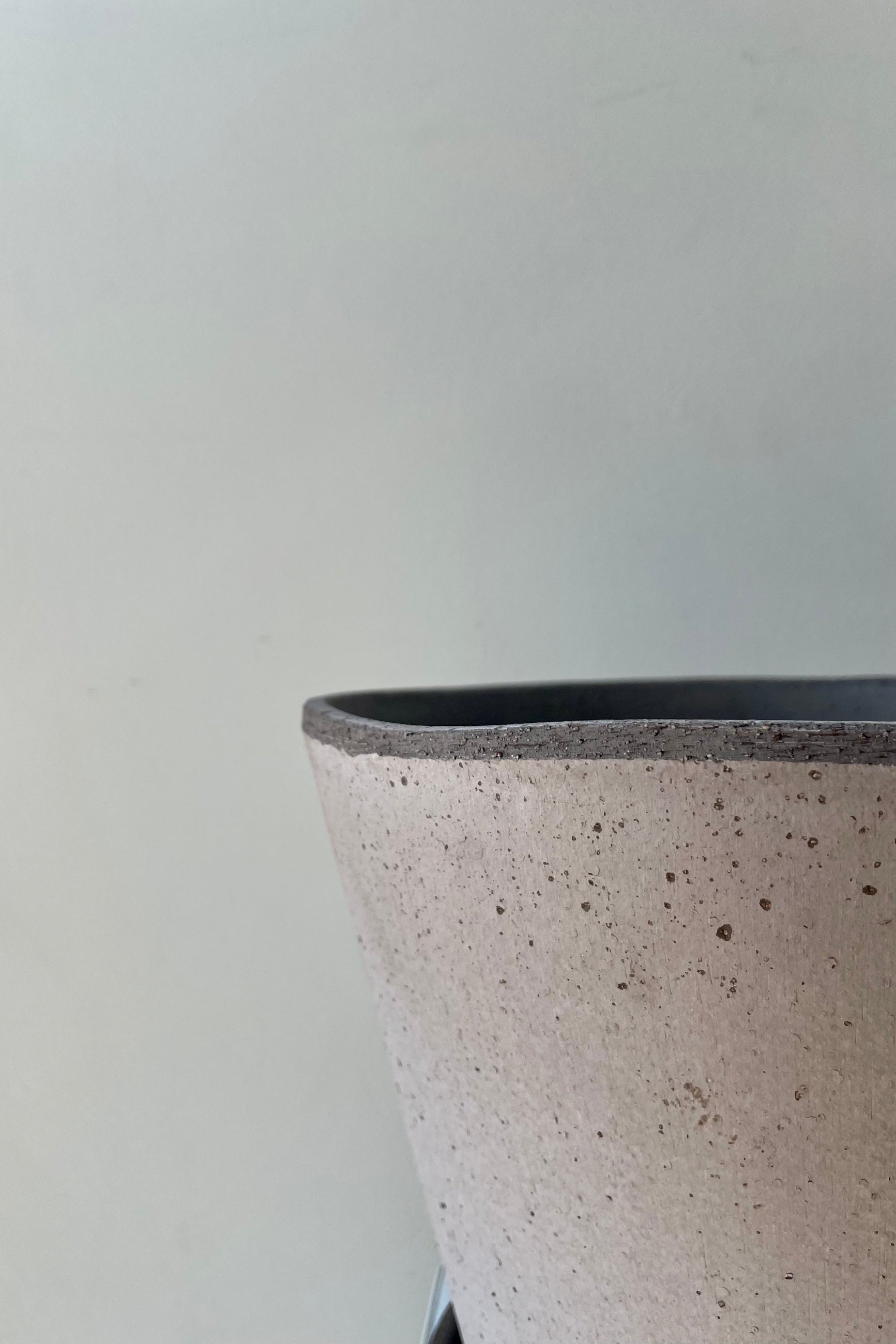 Close up photo of Julie Pot & Saucer grey 9.8” against a white wall ©Sprout Home