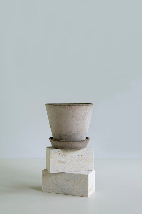 Grey Julie pot and saucer by Bergs Potter on top of some white bricks