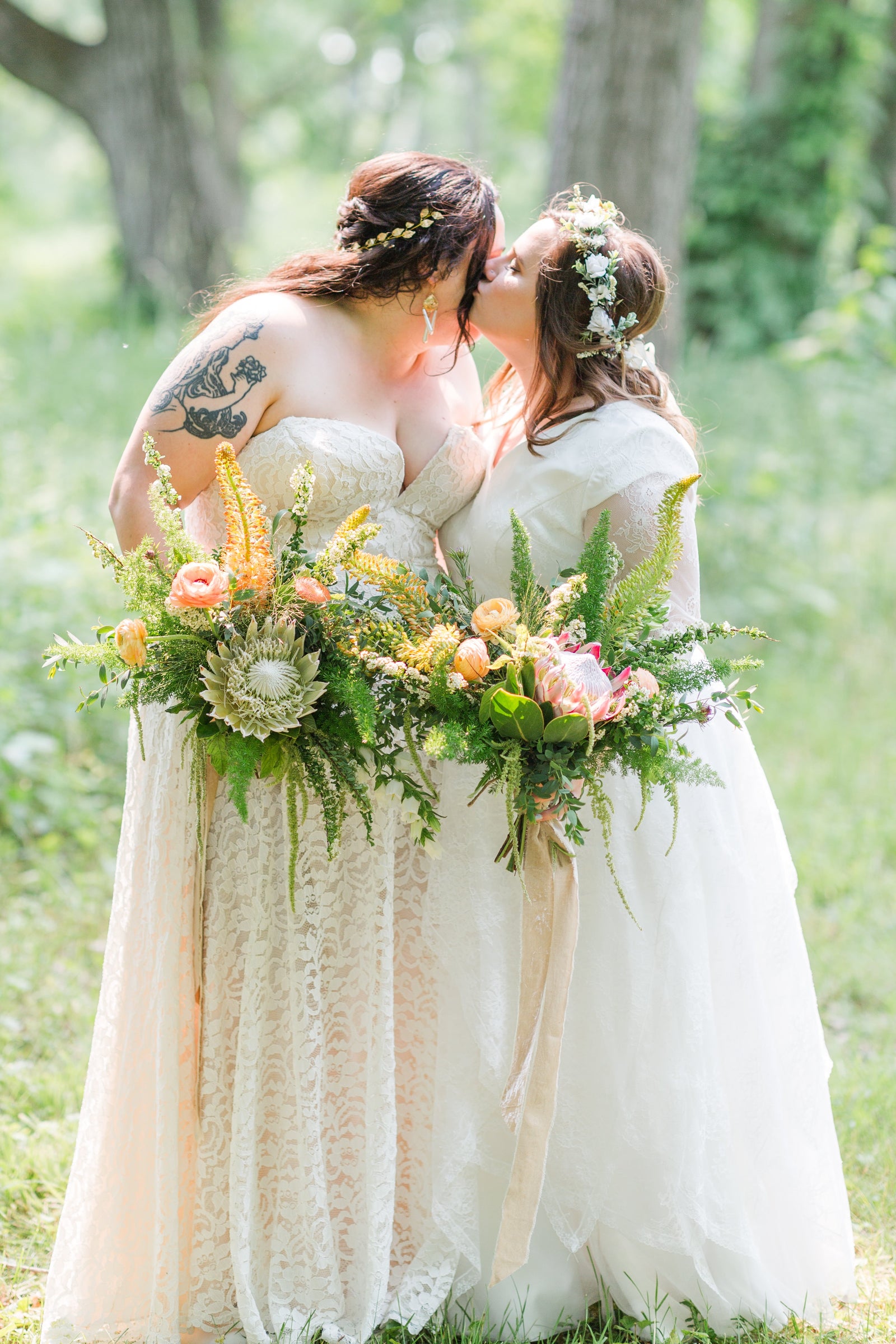 Kim & Megan's elopement. The brides holding floral bouquets by Sprout Home with a forest in the background.  Photograph by www.ajabelman.com