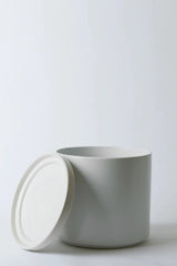 LBE Design Solid Goods planter and saucer in white with its saucer leaning against the pot.