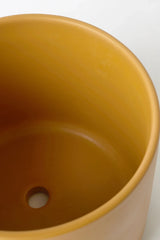 The inside of the Mustard colored LBE Design Solid Goods pot showing the drain hole.