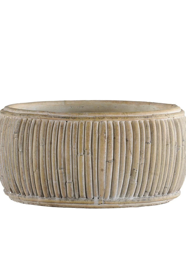 Medium size faux shallow rattan planter empty and against white.