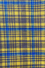 Close photo of a amber yellow plaid linen kitchen towel. The plaid is mostly yellow with taupe and light blue.