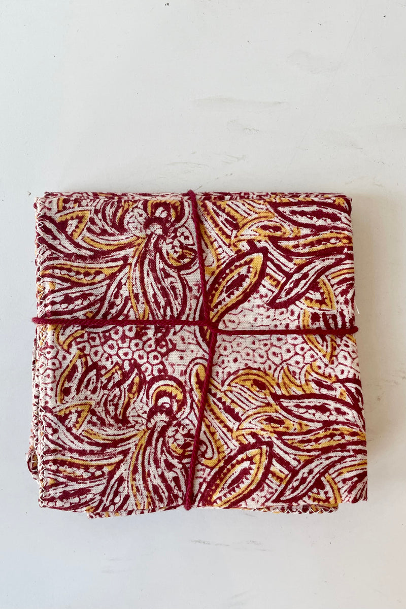 Set of four folded Acacia pattern napkins on a white surface.