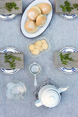 Grey with White stripe linen tablecloth by Fog Linen Work with a table setting in a lifestyle shot shown from above.