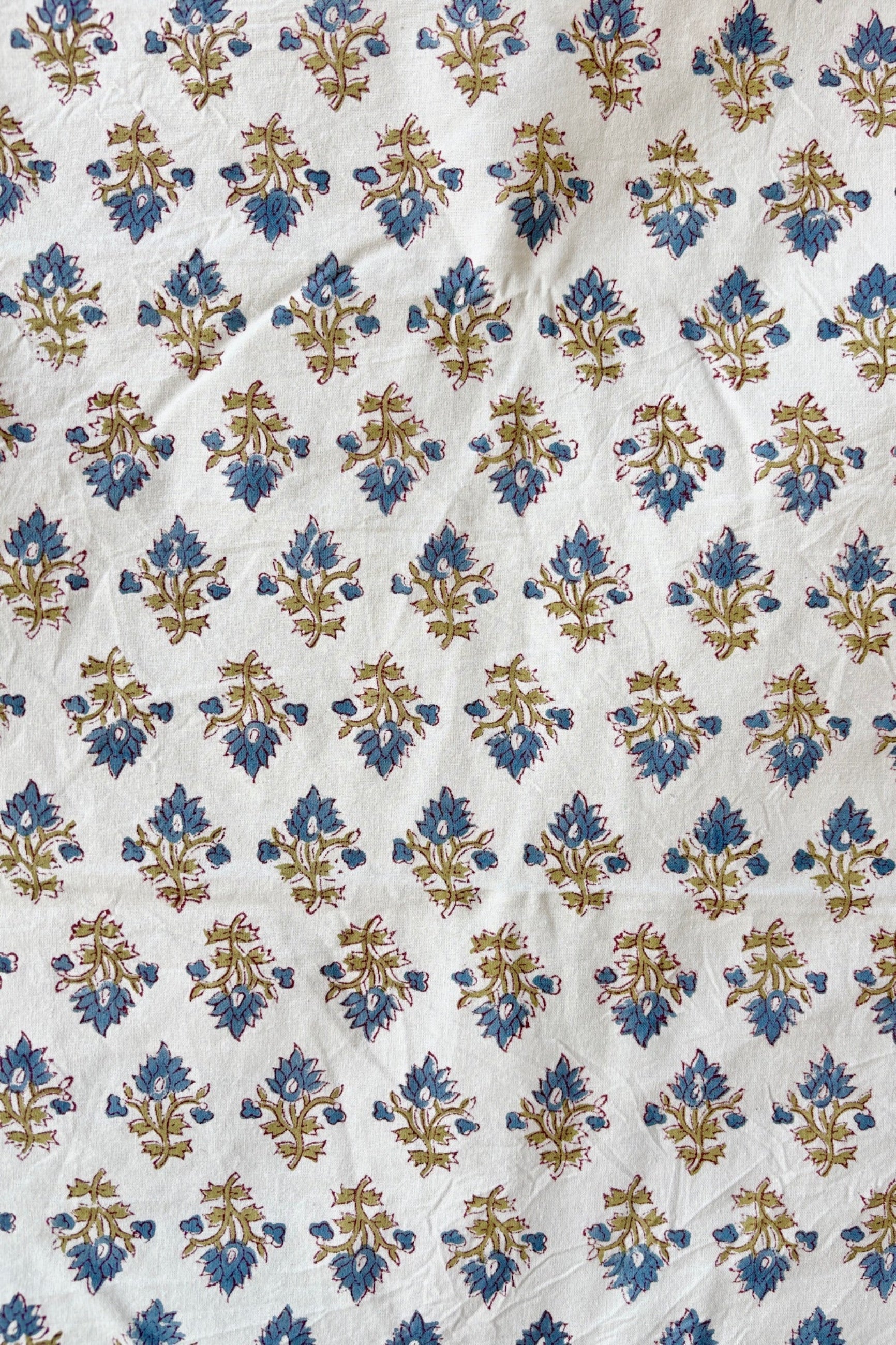 Close up of hand printed Silvia tablecloth with blue and green filagree floral design on a white background ©Sprout Home