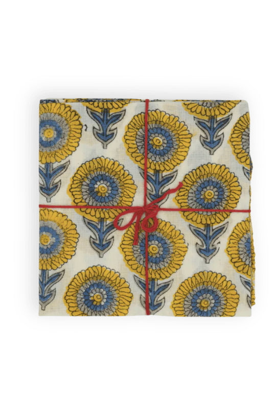 A blue and yellow floral napkin tied with string on a white background ©Suzette a Table