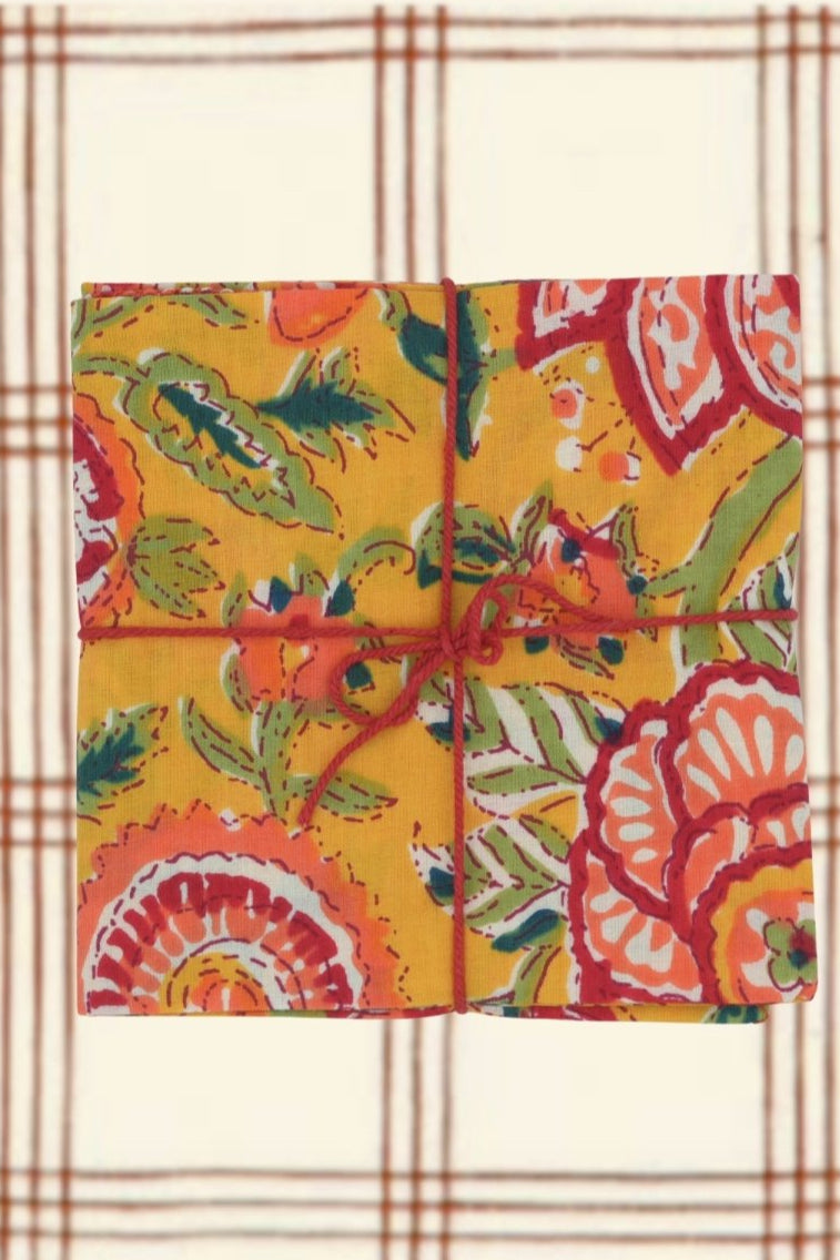Colorful floral patterned napkins on a neutral plaid background ©Suzette a Table