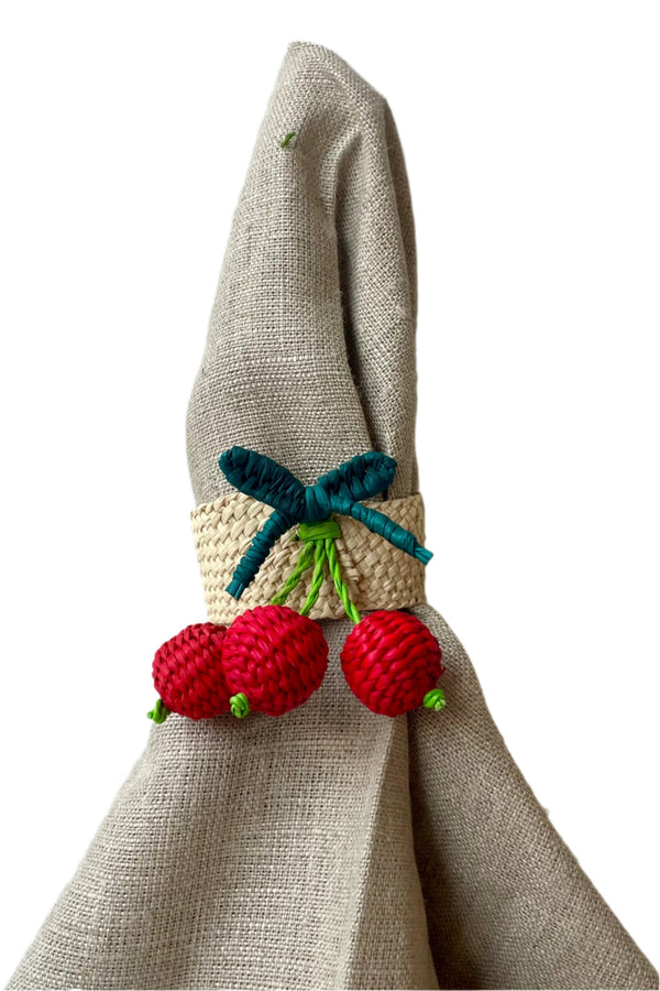 Photo of Cerazas napkin ring with red and green palm fiber around a neutral colored napkin. Shown against a white background.