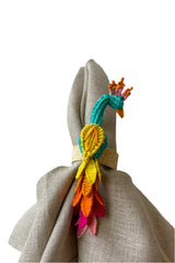 Photo of a colorful Peacock Napkin Ring on a neutral napkin shown in front of a white background.