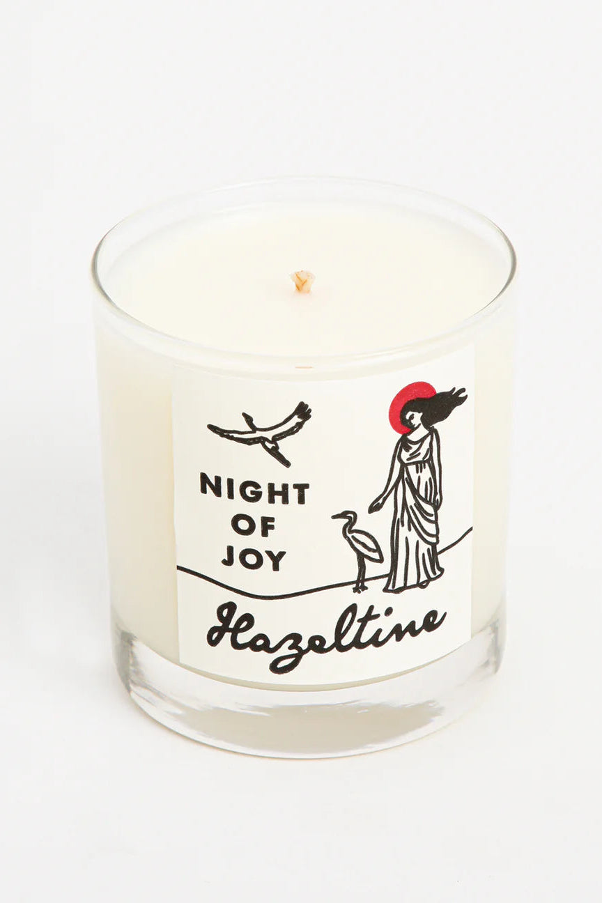 Candle with a label featuring illustrations and text on a white background ©Hazeltine