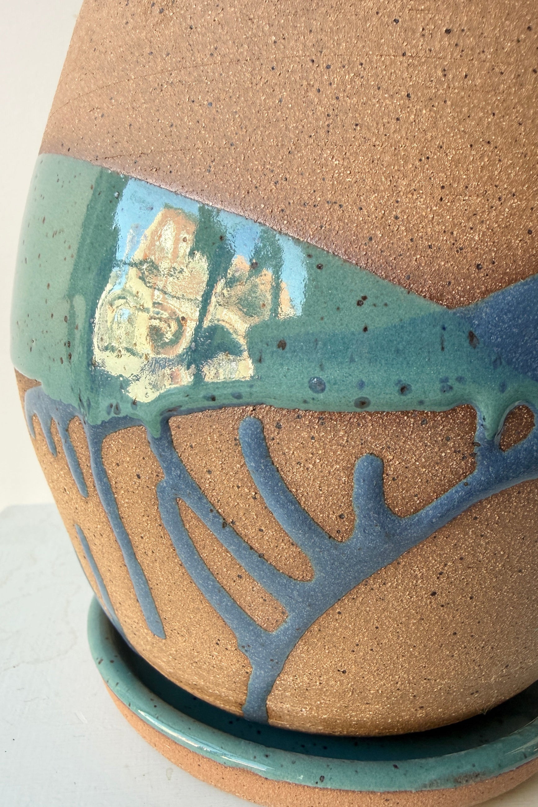 detail of a Christina Kosinski handmade planter with textured denim and teal glaze on a white background ©Sprout Home