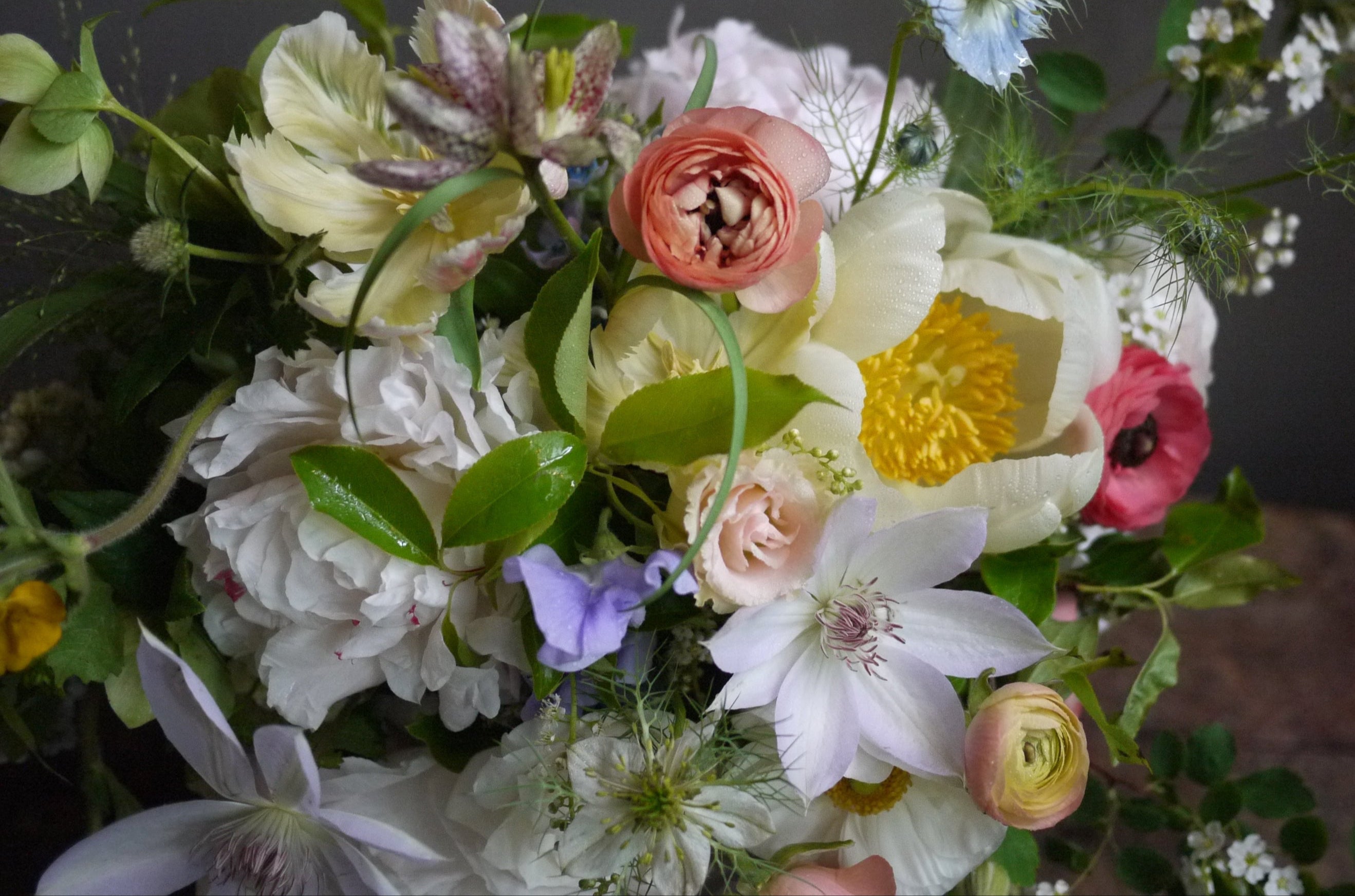 Pastel flowers in an arrangement by Sprout home featuring light purple clematis. 