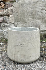 Photo of extra large Patt Pot planter with a textured gray finish against a cement wall.