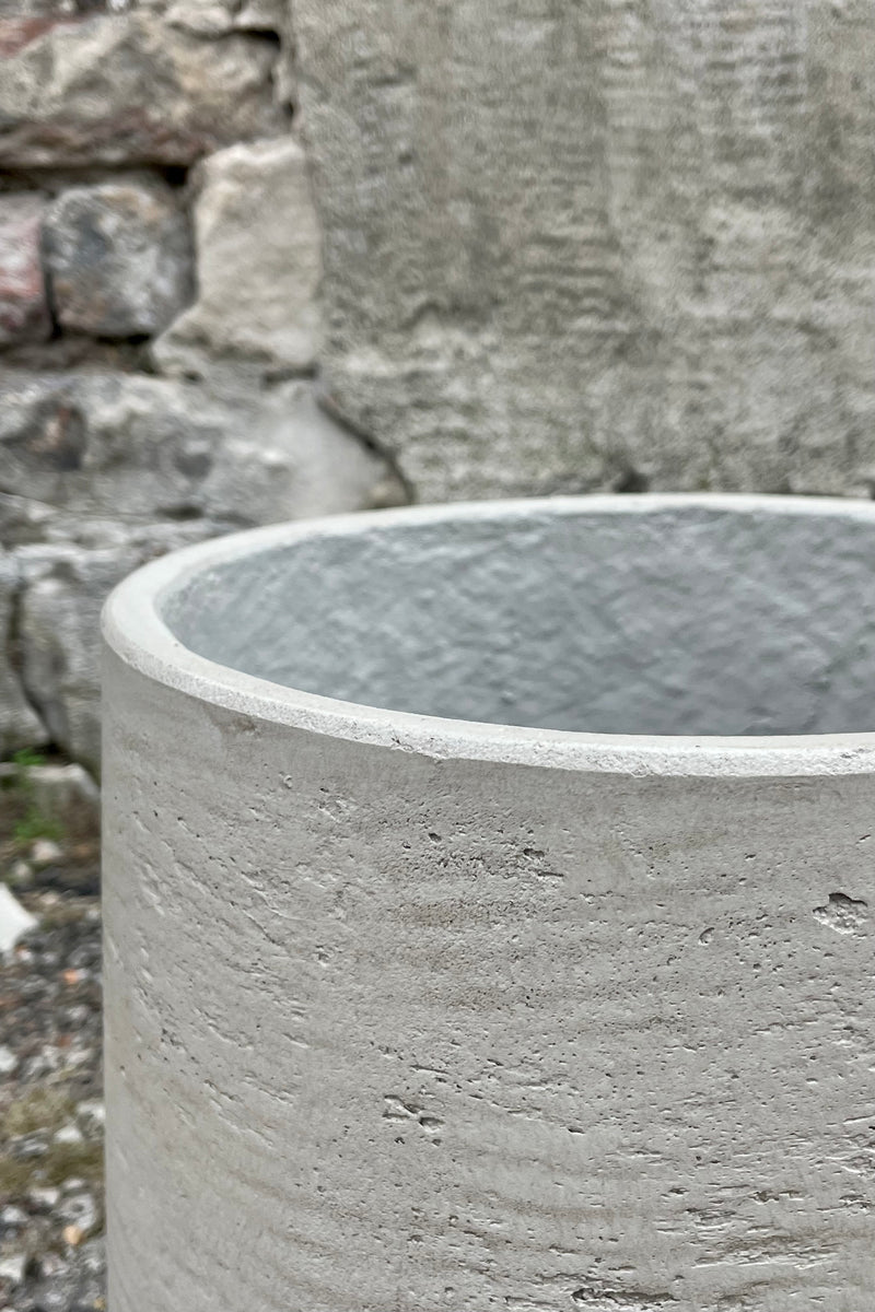 Photo of extra large Patt Pot planter with a textured gray finish against a cement wall looking down.