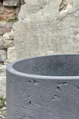 Photo of extra extra large Patt Pot planter with textured matte black finish against a cement wall looking down