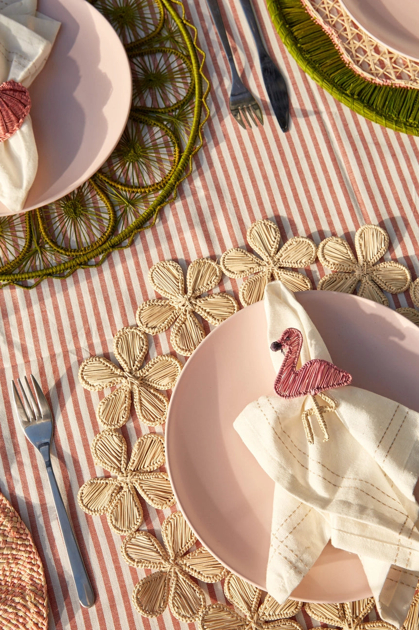Photo of a table setting with utensils and plates and textiles showcasing a woven placemat ©Sprout Home