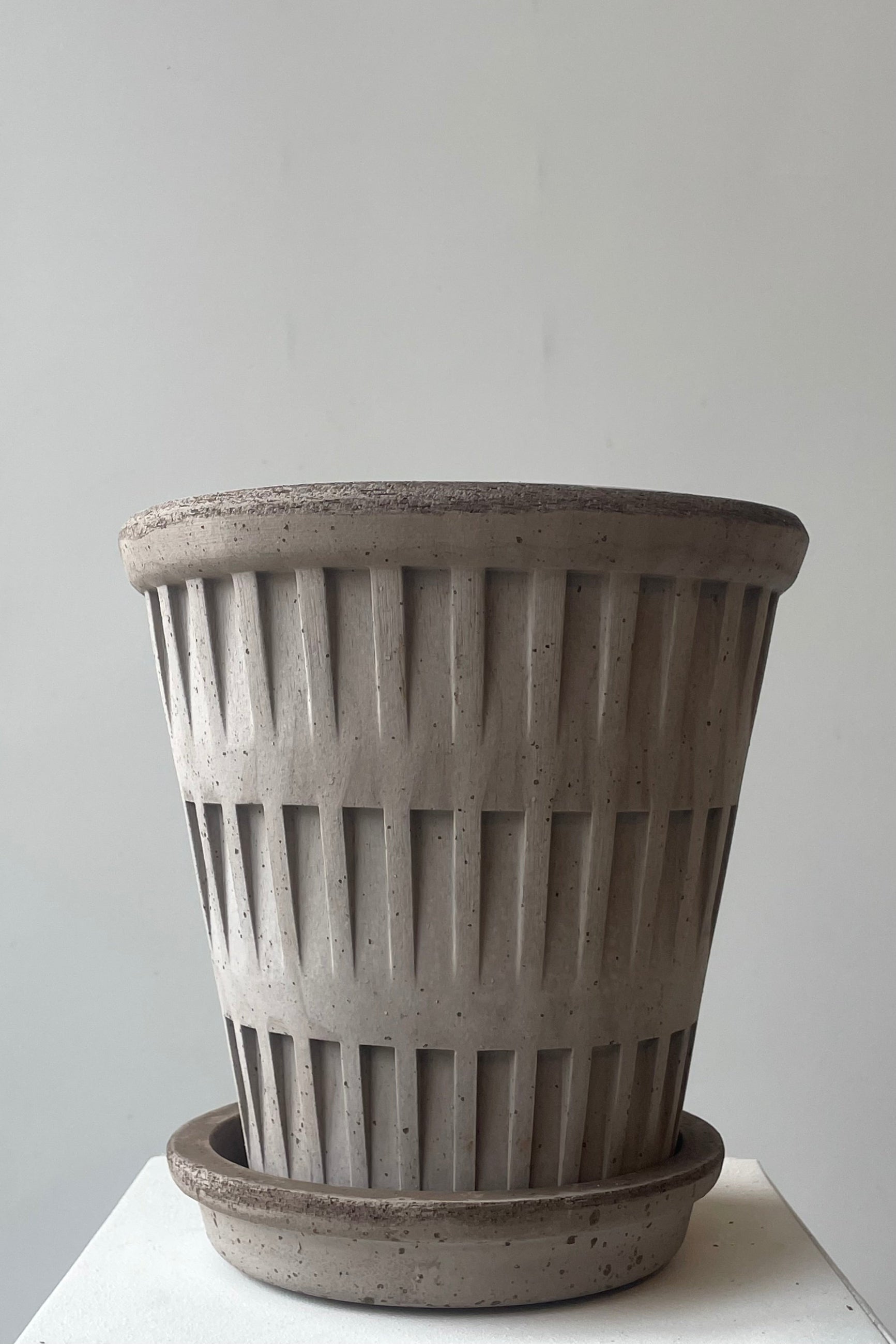 A gray clay planter with saucer on a white background ©Sprout Home