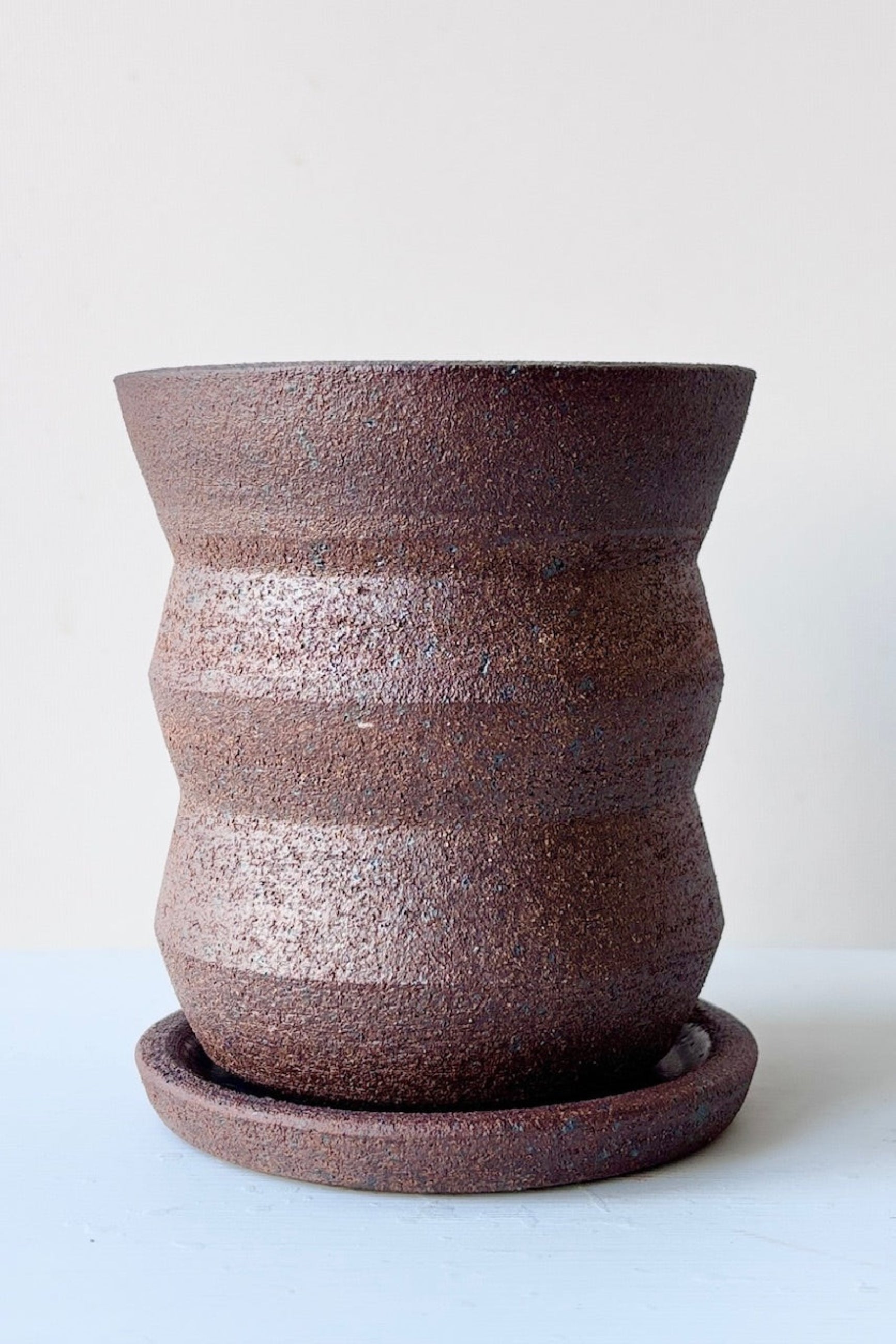 Olivia Snow Ceramics brown angled planter shown from the side against a white wall ©Sprout Home