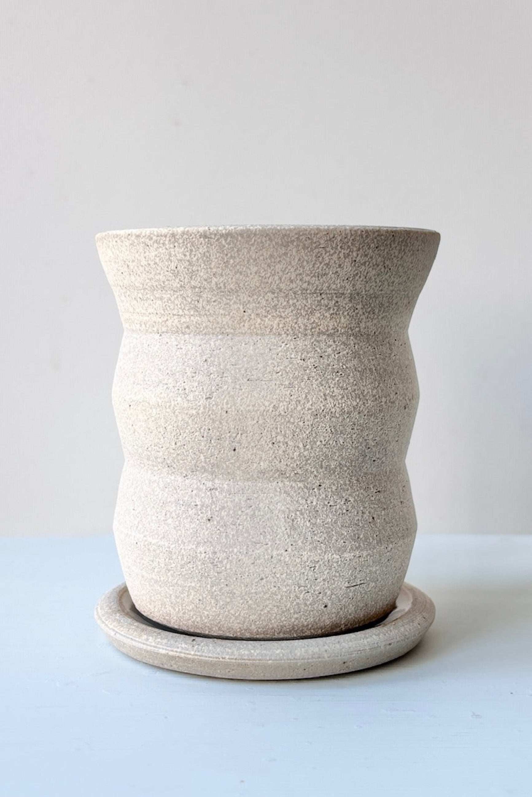 Creme Angled Planter by Olivia Snow Ceramics, displayed against a white wall ©Sprout Home