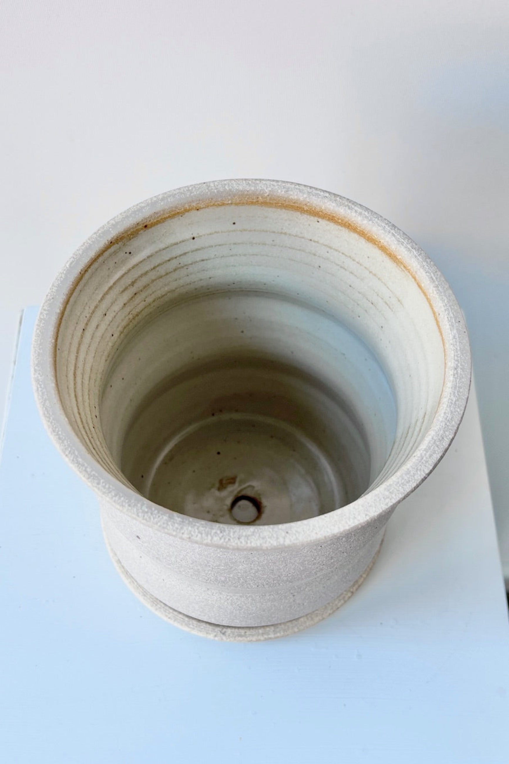 Top view of creme Angled Planter by Olivia Snow Ceramics, empty and viewed from the side. ©Sprout Home