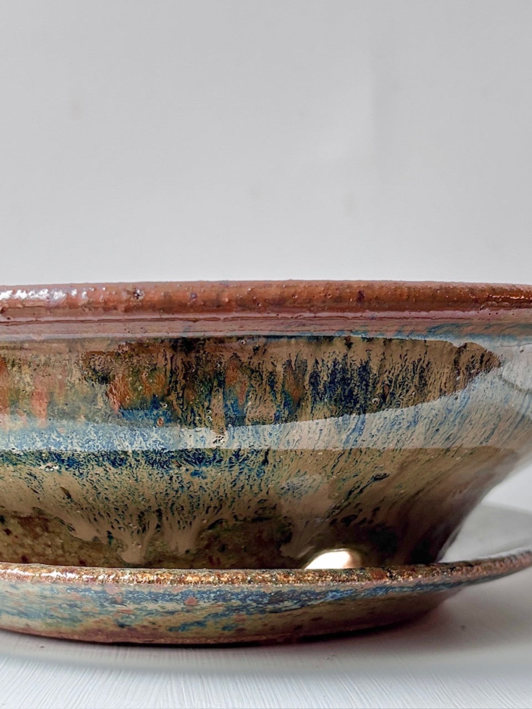Detail of Ivory and Iron glazed large low bowl agaisnt a white surface ©Sprout Home