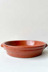 Roasting terra cotta dish looking from the side with a white background.